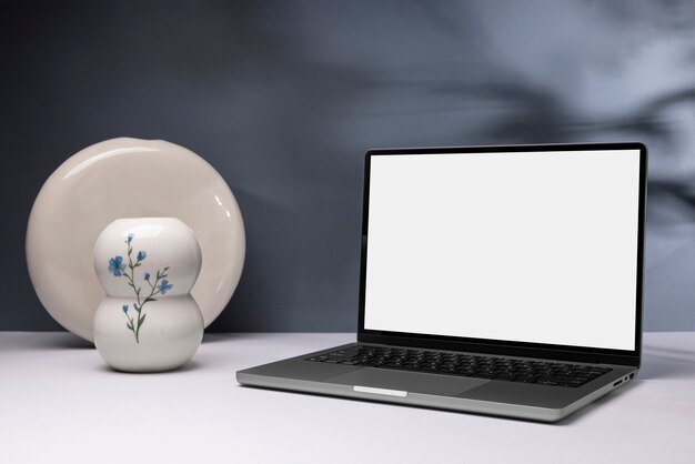 Minimale laptop en bloemenvaas