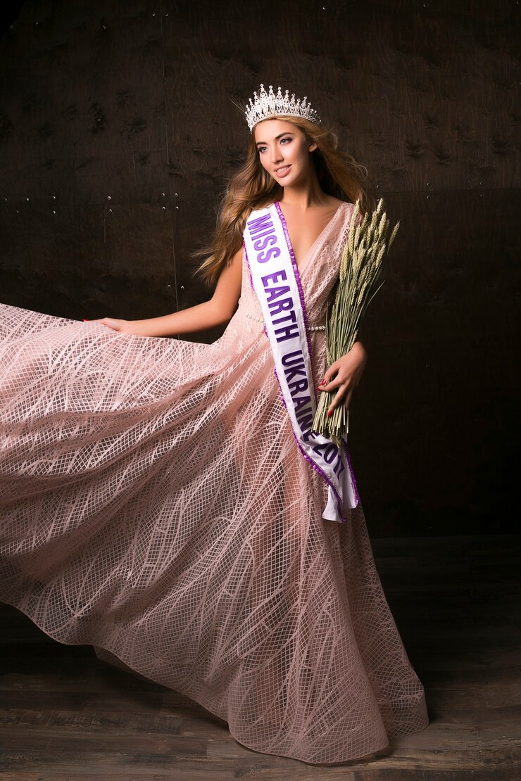 Miss Earth-vrouw die de kroon, het lint en de aartjes van tarwe draagt. Modewedstrijd, mooi model poseren
