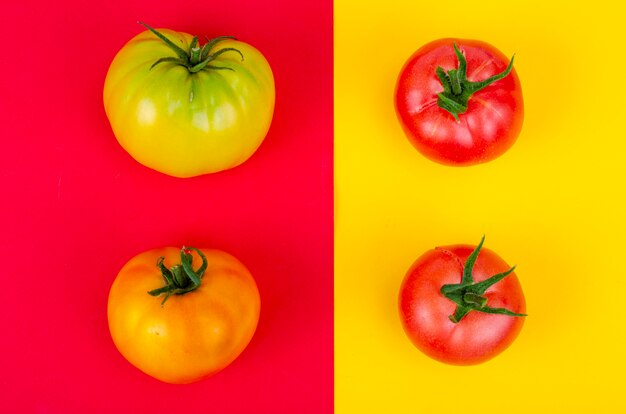 Mix van rijpe kleurrijke tomaten op heldere gele achtergrond. studiofoto.