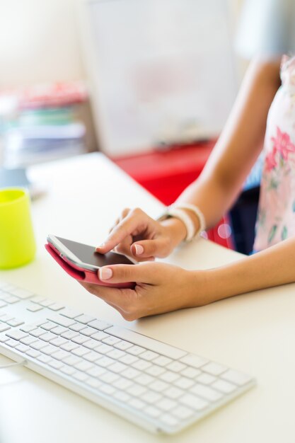 Mobiele telefoon in de hand van een vrouw. Binnenbeeld.