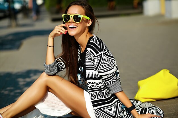 mode stijlvolle mooie jonge brunette vrouw model in zomer hipster kleurrijke casual kleding die zich voordeed op straat achtergrond