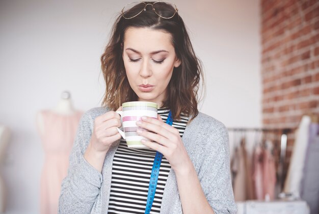 Mode vrouwelijke ontwerper genieten van koffie