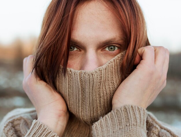 Model bedekkend gezicht met een beige trui