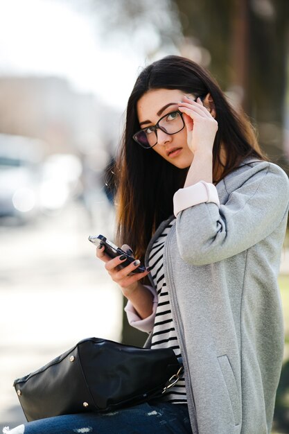 Model midden in de stad met telefoon