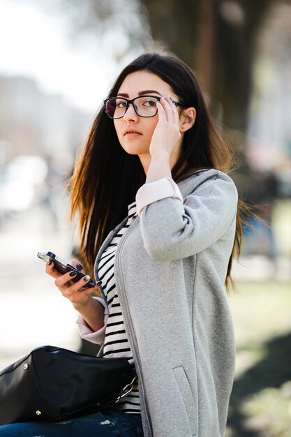 Model midden in de stad met telefoon