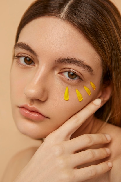 Model poseren met gele bloemblaadjes close-up