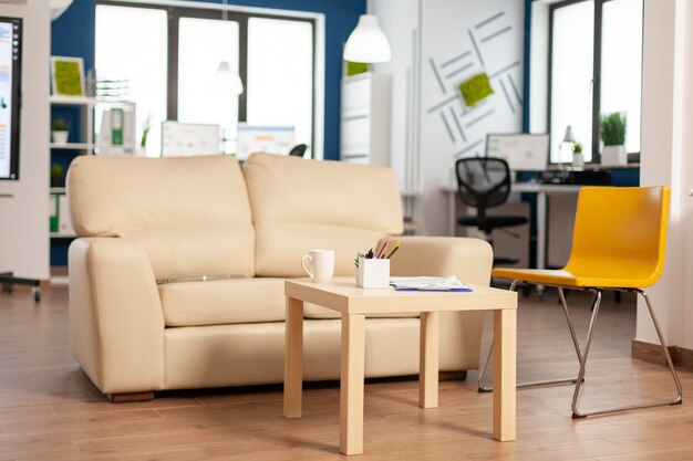 Modern zakelijk relaxzone-interieur met comfortabele bank en oranje stoel