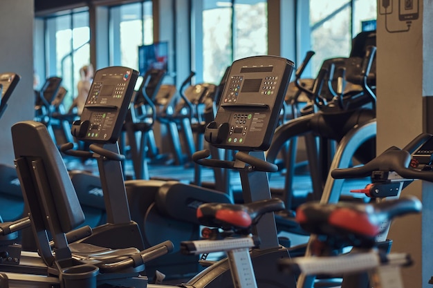 Gratis foto moderne apparatuur in een sportschool binnenshuis. interieur van fitnessruimte met fitness fietsen.