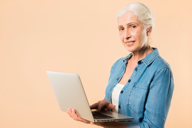 Gratis foto moderne hogere vrouw met laptop