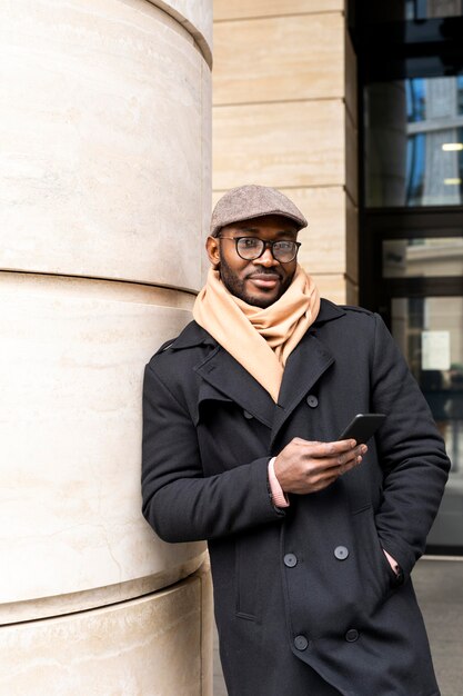 Moderne man met zijn telefoon buitenshuis