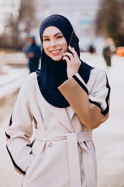 Moderne moslimvrouw die aan de telefoon praat