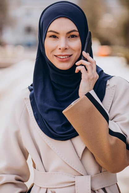 Moderne moslimvrouw die aan de telefoon praat