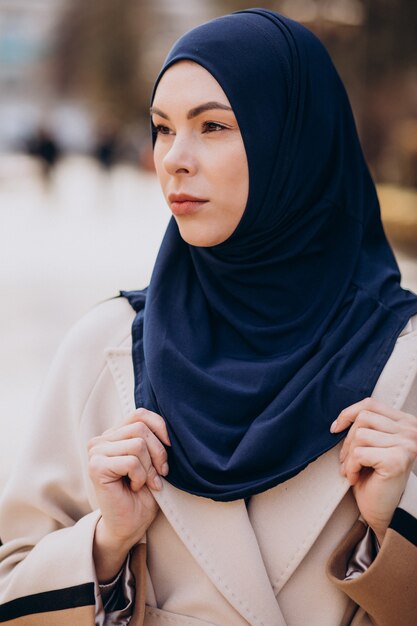 Moderne moslimvrouw die een hoofddoek draagt die op straat loopt