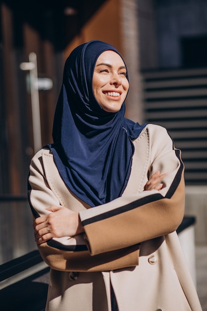 Moderne moslimvrouw die een hoofddoek draagt die op straat loopt