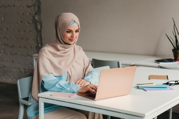 Moderne moslimvrouw in hijab in kantoorkamer