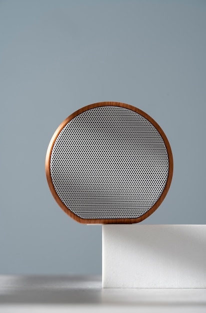 Gratis foto moderne ronde draadloze luidspreker met strak ontwerp op een geometrisch podium