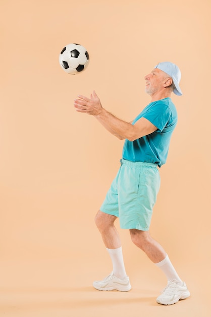 Moderne senior man met voetbal