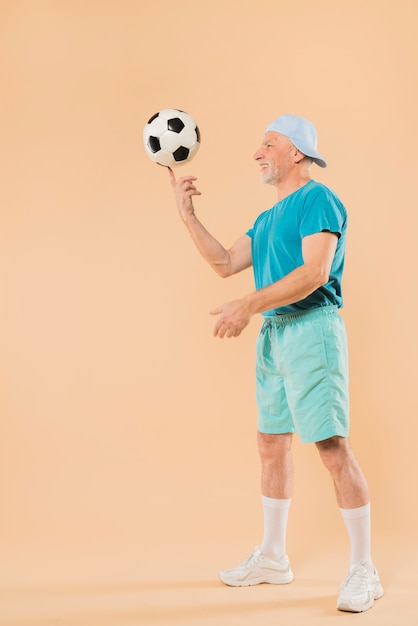 Gratis foto moderne senior man met voetbal