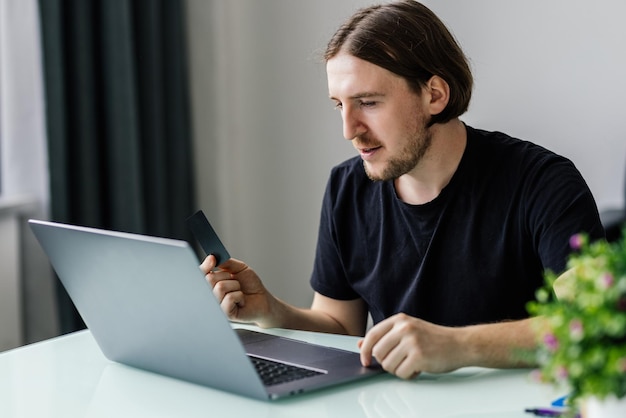 Moderne technologie zakelijke carrière e-commerce en online handelsconcept Zakenman met creditcard in één had en toetsenbord op laptop met andere hand die transactie maakt