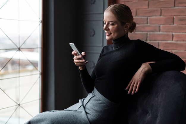 Moderne vrouw die mobiel bekijkt