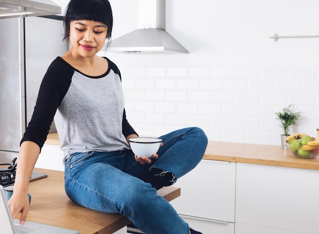 Moderne vrouw die ontbijt in de keuken heeft