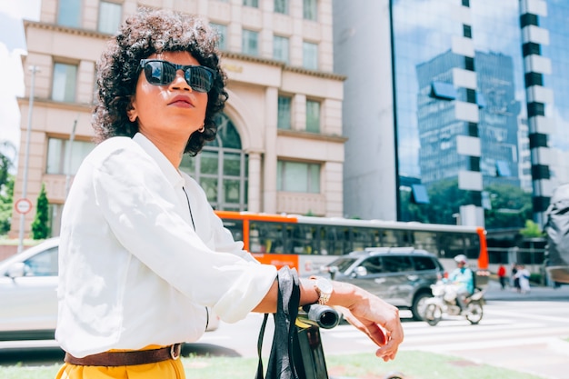 Moderne vrouw in een stad met een elektrische autoped