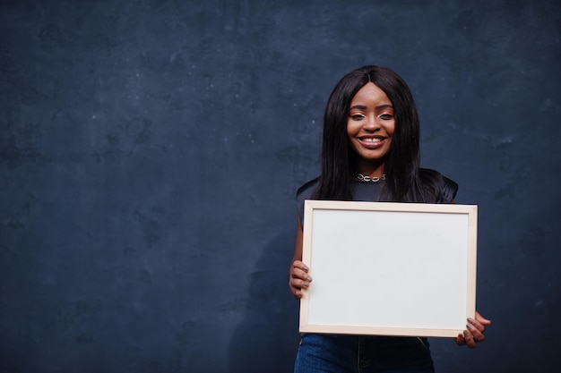 Modieuze Afrikaanse vrouw houdt leeg wit bord vast