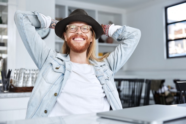 Modieuze hipster-man gekleed in een stijlvolle zwarte hoed en denimoverhemd