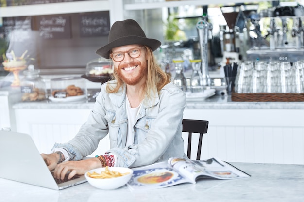 Modieuze hipster-man gekleed in een stijlvolle zwarte hoed en denimoverhemd