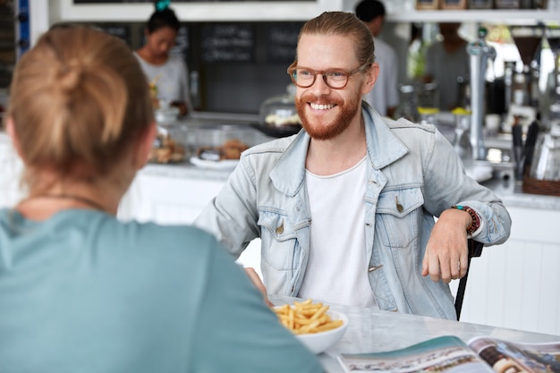 Gratis foto modieuze hipster man zit met een vrouw in café