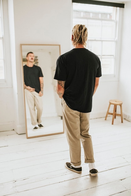 Gratis foto modieuze man die zichzelf in de spiegel bekijkt