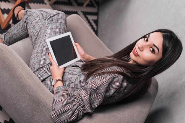 Modieuze vrouw die met tablet camera bekijkt