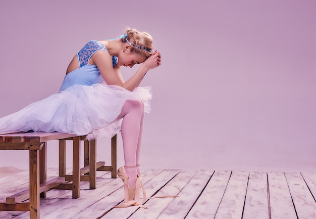 Gratis foto moe balletdanser zittend op de houten vloer