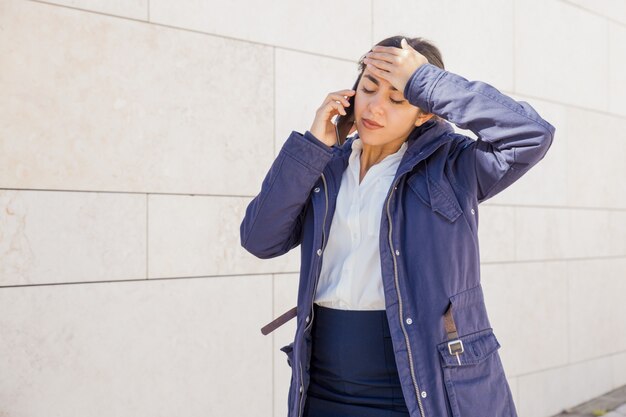 Moe kantoor meisje spreken op mobiele telefoon