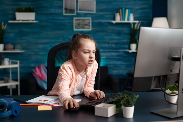 Moe overwerk klein kind dat schoolinformatie op de computer doorbladert