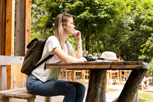 Gratis foto moe reiziger zitten en wegkijken