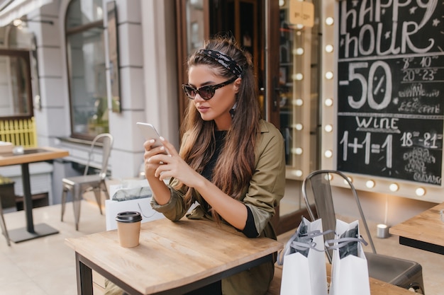 Moe shopaholic vrouw koelen op terras in herfstdag