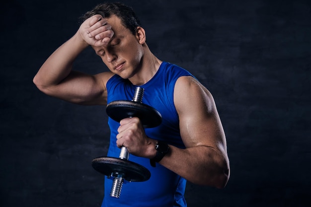 Moe sportieve man in een blauwe sportkleding na een zware training.