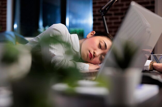 Moe uitvoerend manager met burn-outsyndroom slapen op het werk vanwege extreme vermoeidheid. Uitgeputte financiële accountant die lijdt aan slaperigheid na overuren.