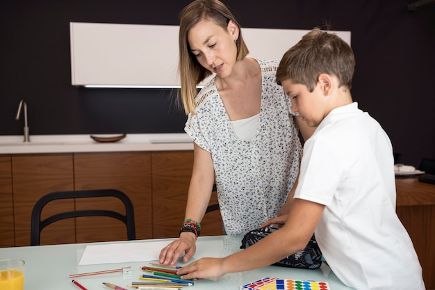 Gratis foto moeder die zoon helpt met huiswerk