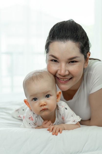 Moeder en baby die in het bed leggen