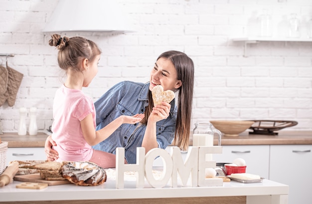 Moeder en dochter bereiden gebakjes in de keuken.