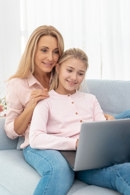 Moeder en dochter die aan laptop werkt