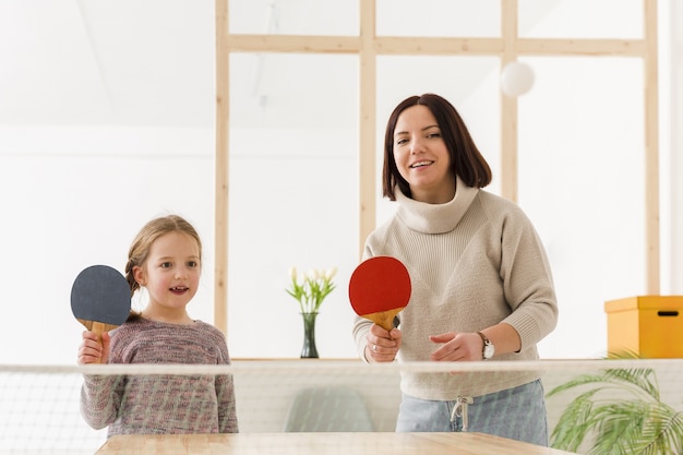 Moeder en dochter die pingpong spelen