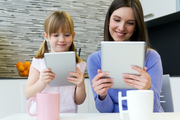 Moeder en dochter gebruiken een digitale tablet in de keuken