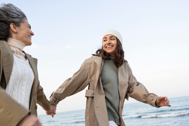 Moeder en dochter hand in hand terwijl ze samen op het strand zijn