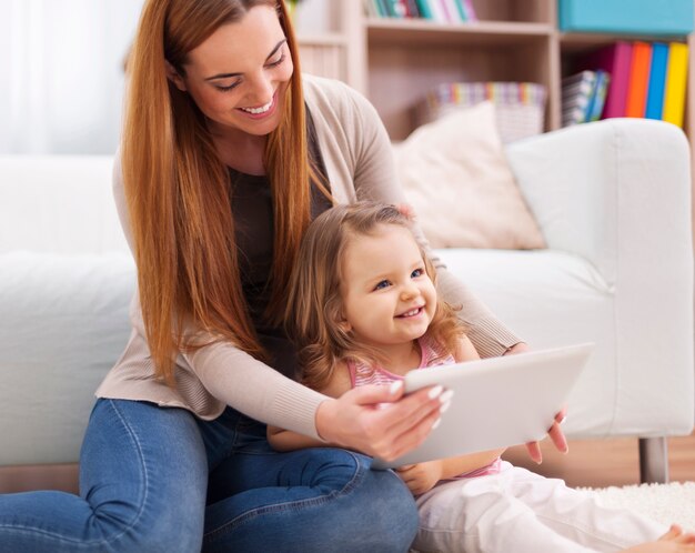 Moeder en dochter hebben plezier tijdens het gebruik van digitale tablet