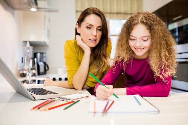 Moeder en dochter helpt dochter met haar huiswerk