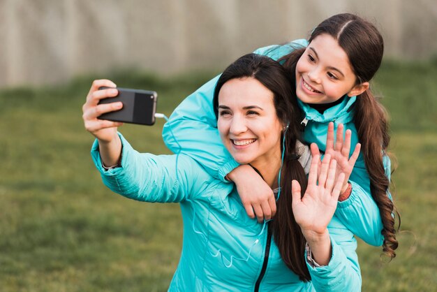 Moeder en dochter in sportkleding nemen een selfie