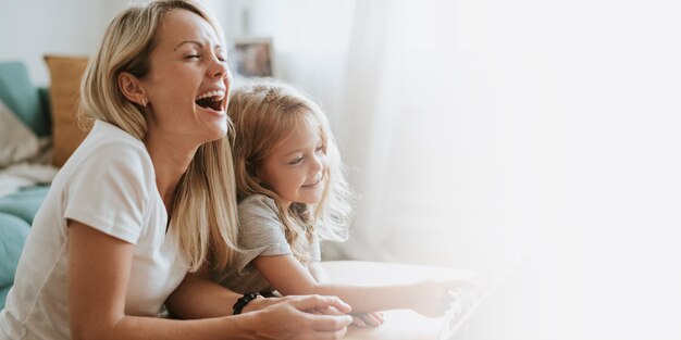 Moeder en dochter kijken naar een tekenfilm op een digitale tablet